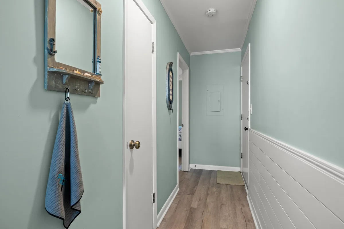 A welcoming interior space featuring a mirror, towel rack, and doors, suggesting an entry or transitional area that could connect to the laundry room or storage spaces. The visible organizational elements hint at practical amenities and everyday ease.